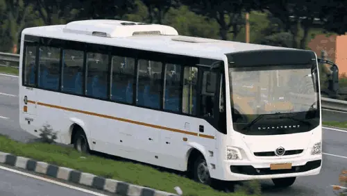 A white mini bus being piloted by a professional driver at high speeds