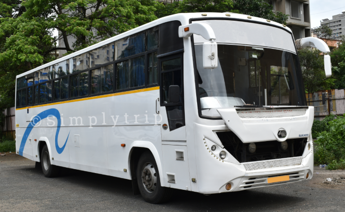 White coloured 40 seater bus with blue curtains